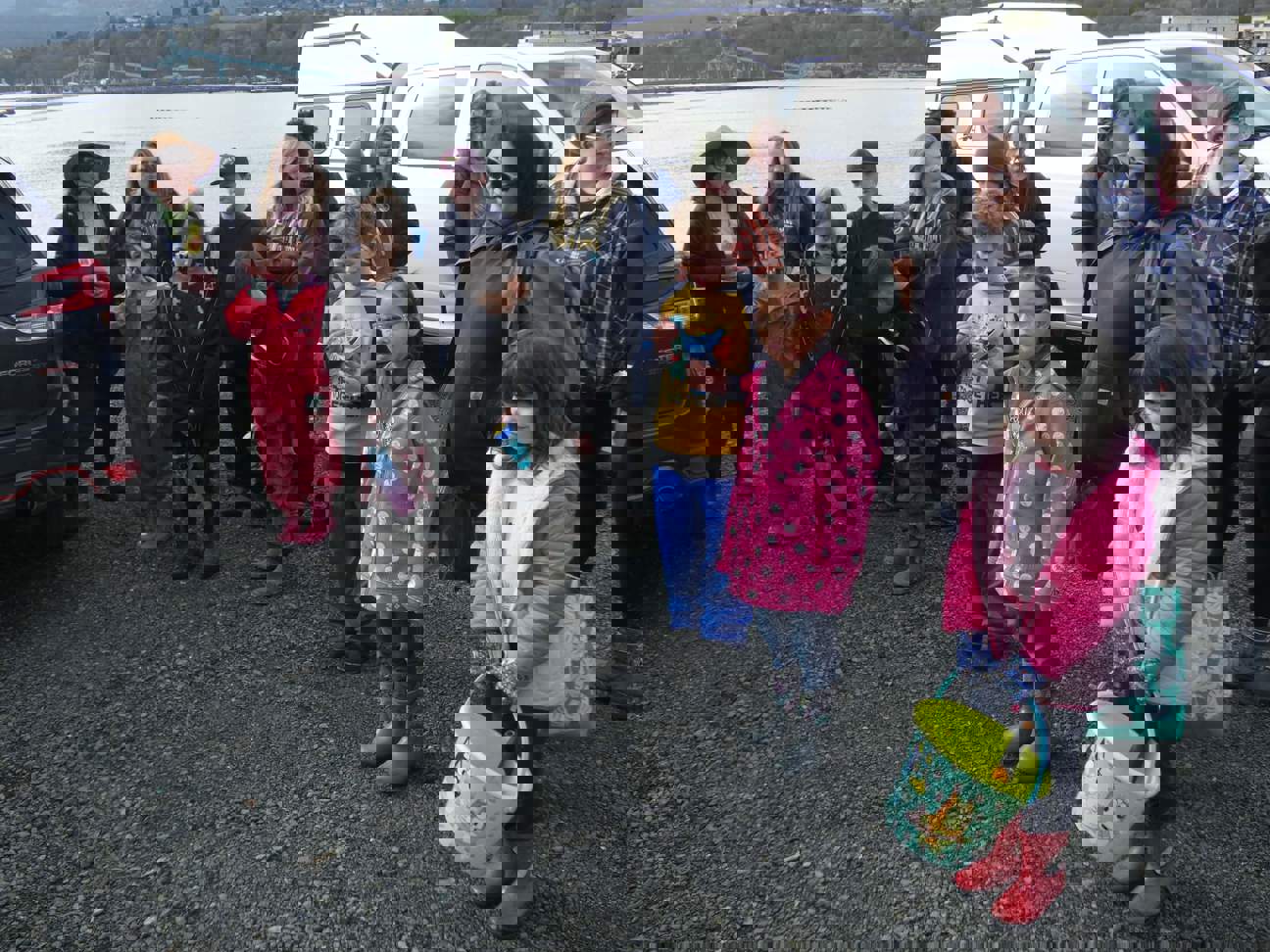 About a dozen children and chaperones cluster around listening to instructions for the day's planting